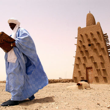 Man reading a manuscript on the roof of Djingareyber Mosque, Timbuktu